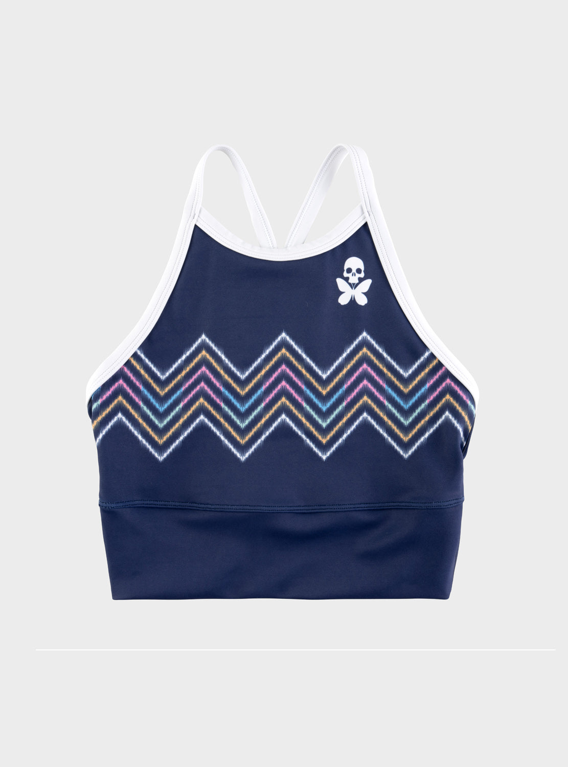 A navy blue halter crop top with a multicolor chevron pattern across the bust and a small white skull-and-butterfly logo on the upper right chest, shown on a light gray background.