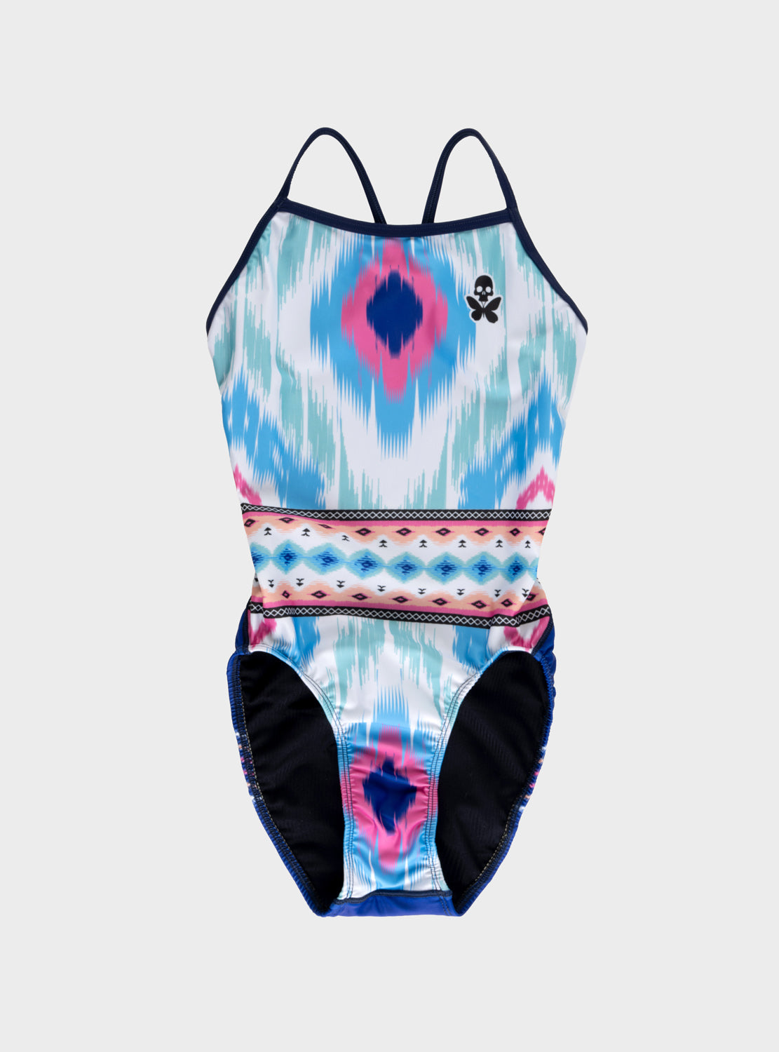 A woman's one-piece swimsuit with a vibrant blue, pink, and white geometric pattern, featuring thin racerback straps and a small black skull butterfly logo on the chest, set against a solid gray background.