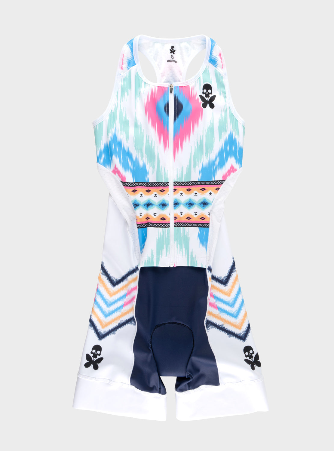 A sleeveless triathlon one-piece suit with a colorful geometric ikat pattern in pink, blue, and white, featuring a central zipper, a patterned horizontal band, and dark navy leg panels with small black skull  butterfly motifs near the cuffs.